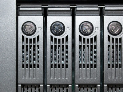 Detailansicht von Serverlaufwerken in einem Rack mit Lüftungsschlitzen und LED-Anzeigen.