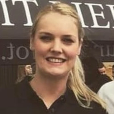 Hannah Rahenbrock lächelt in einem schwarzen Polo-Shirt vor einem Hintergrund mit Text.