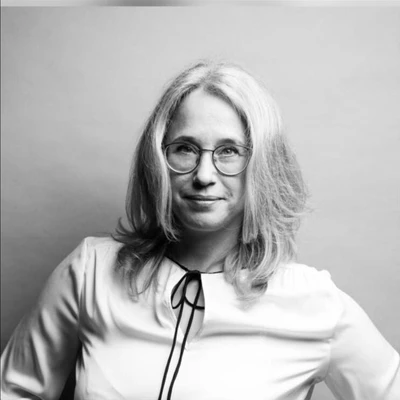 Porträt von Jegus mit Brille und blonder, schulterlanger Frisur in einem neutralen Hintergrund.